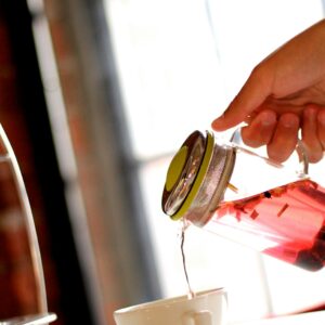 Früchtetee, der in Tasse gegossen wird