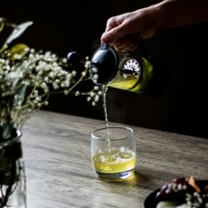 Grüner Tee, der in Glas gegossen wird