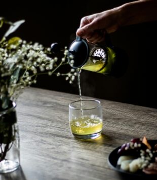 Grüner Tee, der in Glas gegossen wird