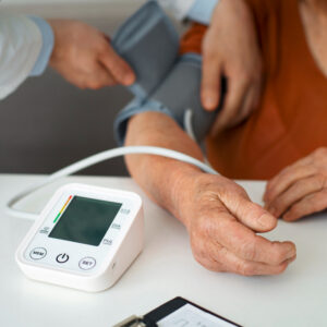 Ein Bildausschnitt, auf dem zusehen ist, wie eine medizinische Fachperson einer anderen den Blutdruck misst.