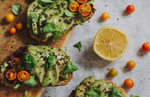 Ein Brett mit vier Avocado Brotscheiben.