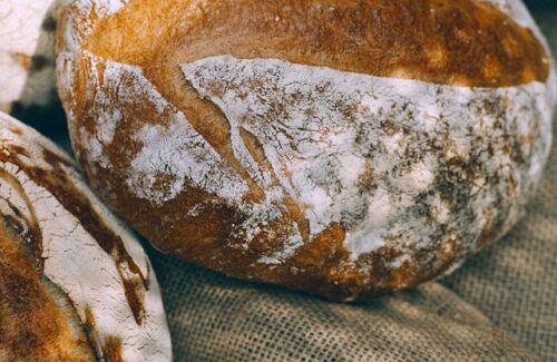Drei Leibe frisches Brot sind auf einem Leinentuch platziert.