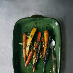 Eine Auflaufform mit gebackenen bunten Karotten aus dem Ofen.