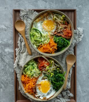 Zwei asiatische Gemüsebowls mit Reis und Ei.
