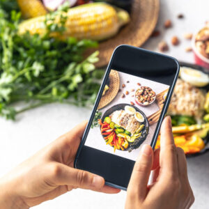 Ein Auschniit eines Handydisplays, auf dem ein Foto von einem leckeren Essen gemacht wird.