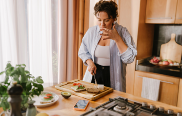 Frau steht in der Küche und bereitet gesundes essen zu