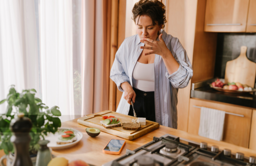 Frau steht in der Küche und bereitet gesundes essen zu