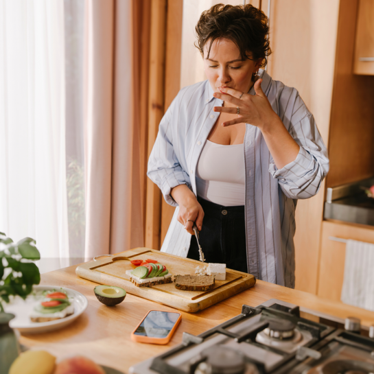 Frau steht in der Küche und bereitet gesundes essen zu