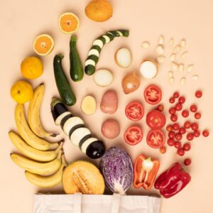Obst und Gemüse fällt ästhetisch geschnitten aus einer Tasche