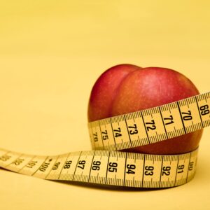 Ein Apfel wird von einem Maßband umschlungen