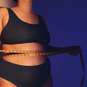 Ein weiblicher Torso ist mit einem Maßband umschlungen