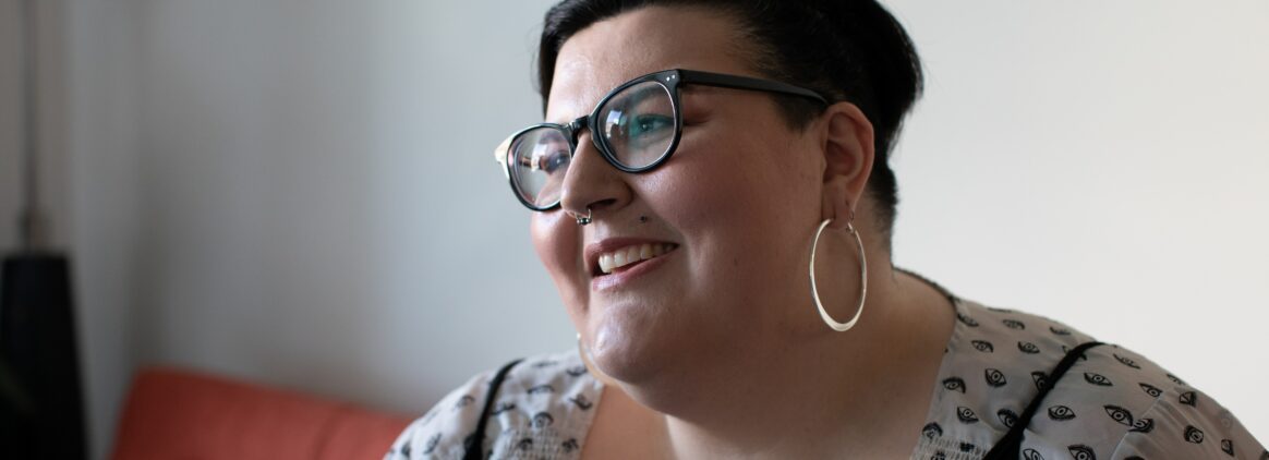 Overweight woman on a couch smiling