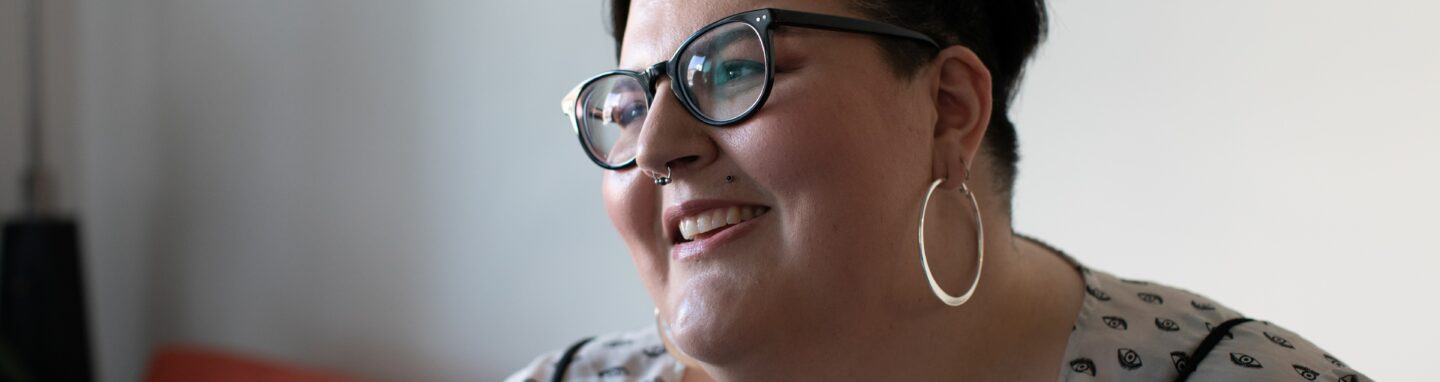 Overweight woman on a couch smiling