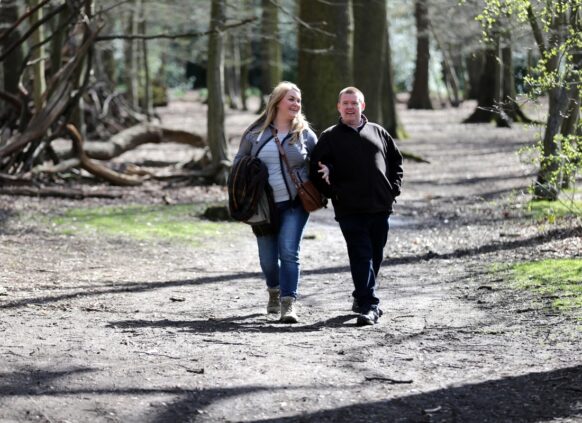 Couple walking down a path in a forest