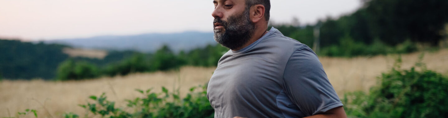 Close up shot of a stout man running in nature