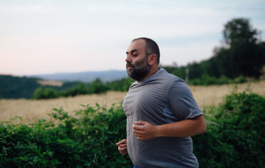 Close up shot of a stout man running in nature