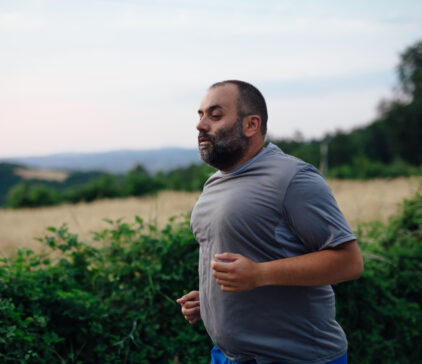 Close up shot of a stout man running in nature