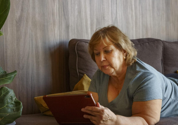 Woman on a sofa looking at a tablet