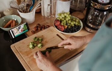 Person using recipe app to cook healthy meal