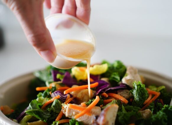 Pouring dressing onto a healthy salad