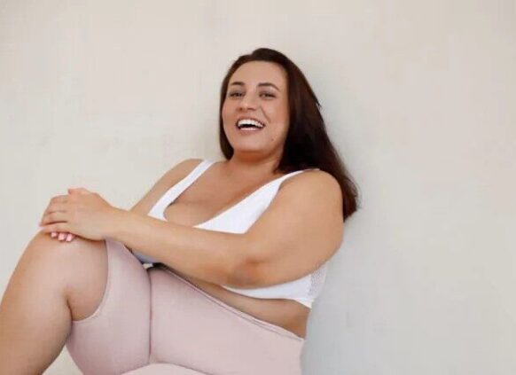 Overweight woman in activewear and laughing