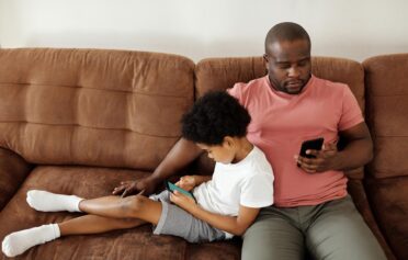 Man with son on the sofa on his phone