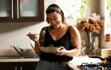 Woman happily enjoying a home-cooked meal in her kitchen