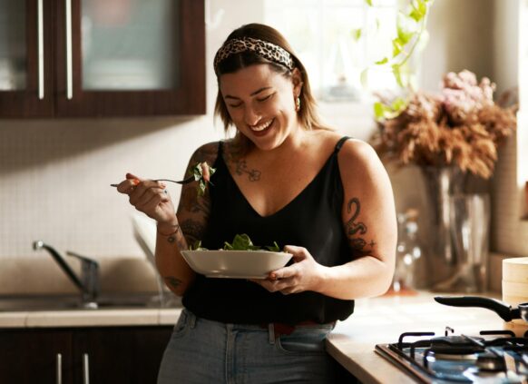 Woman happily enjoying a home-cooked meal in her kitchen