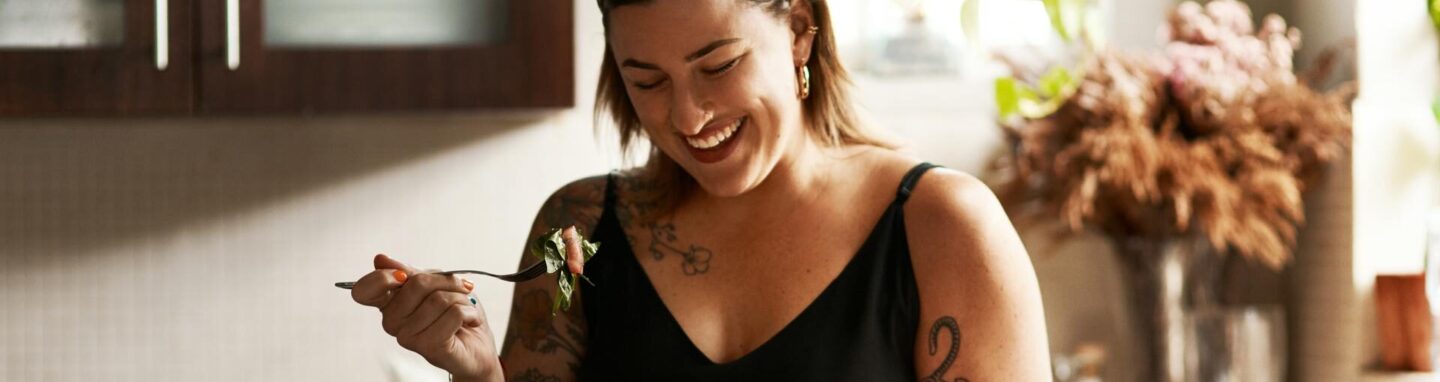 Woman happily enjoying a home-cooked meal in her kitchen