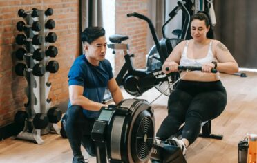 Woman with overweight at the gym using the rowing machine