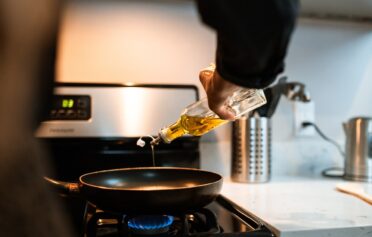 Person pouring cooking oil into a pan