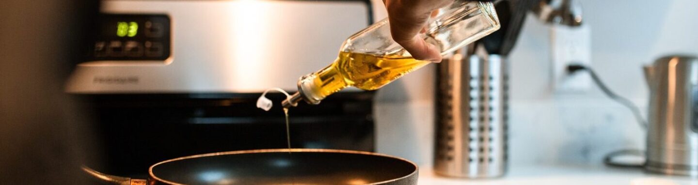 Person pouring cooking oil into a pan