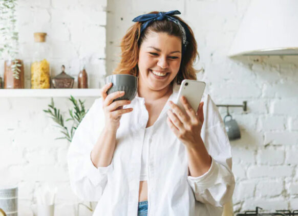 Happy woman with cup and phone