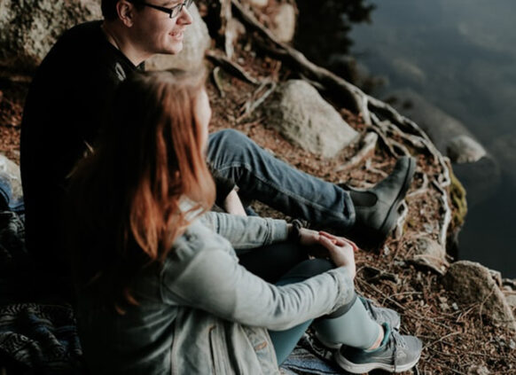 Two people outside by a lake in the winter