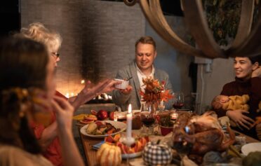A group eating dinner happily at a festive table