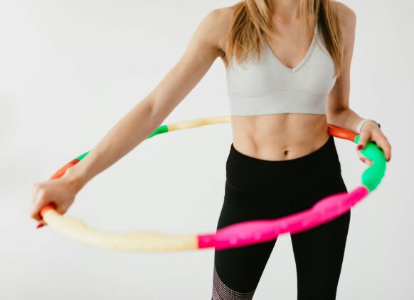 A woman in a sport outfit. Workout with a hula hoop.