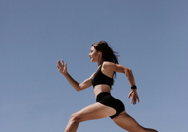 Woman running in shorts and sport's bra in the daylight.