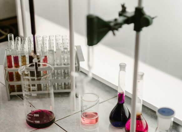 Laboratory glassware with colorful chemical solutions, representing health markers in medical testing.