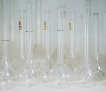 Empty glass volumetric flasks arranged in a laboratory setting.