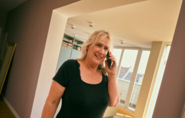 Smiling woman talking on the phone at home.