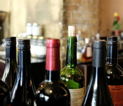 Assorted wine bottles on a bar counter with corks and screw caps.
