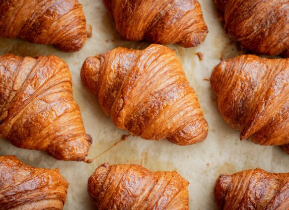 Freshly baked golden brown croissants on parchment paper