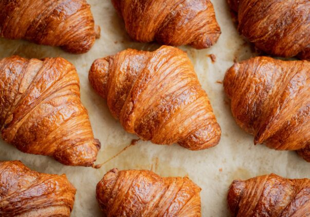 Freshly baked golden brown croissants on parchment paper