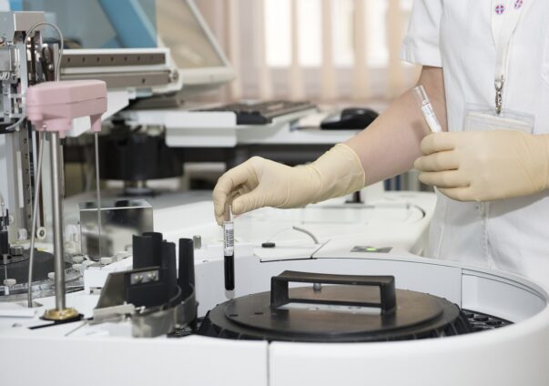 Laboratory technician handling blood samples with medical equipment