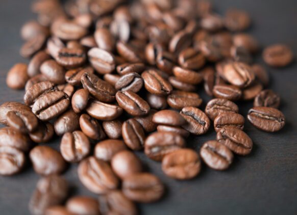 Close-up of roasted coffee beans on a dark surface