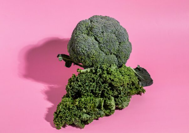 Fresh broccoli and kale on a pink background