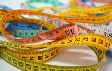 Colorful measuring tapes coiled and overlapping on a flat surface
