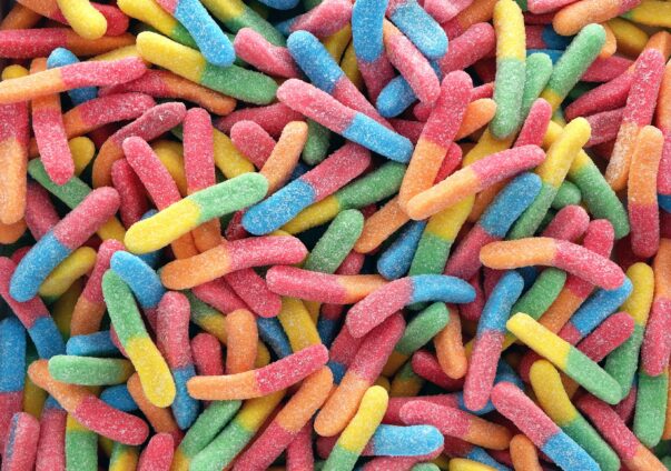 Colorful sour gummy worms covered in sugar