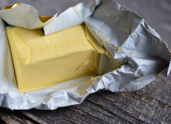 Unwrapped block of butter on rustic wooden surface