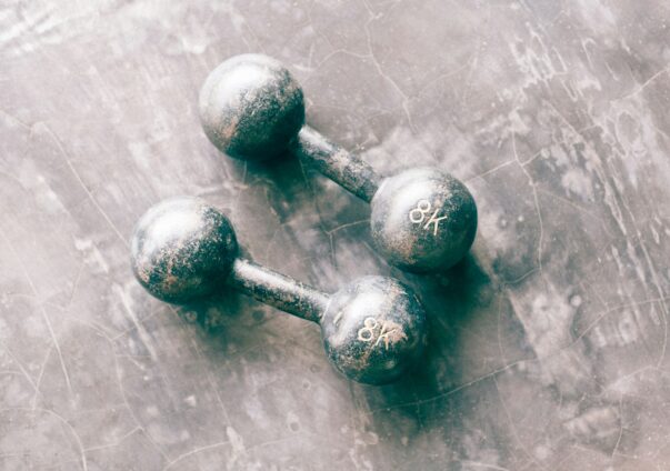 Two vintage 8kg dumbbells on concrete gym floor